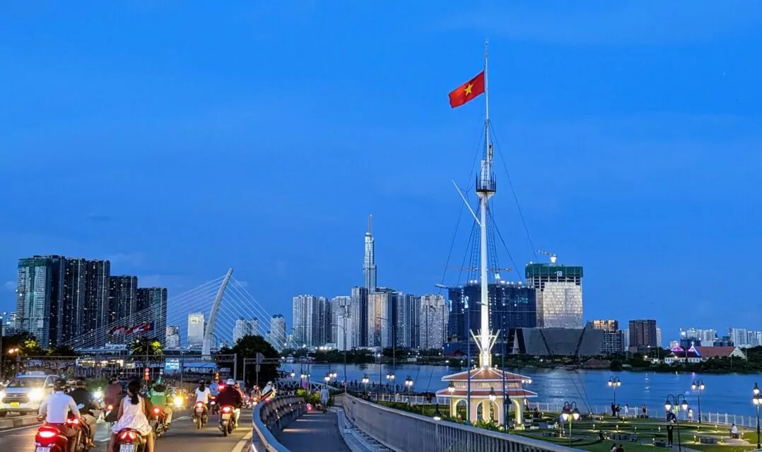 View from a bridge between District 4 and District 1 during the blue hour next to the waterfront by the Sài Gòn River and towards Bình Thạnh with Vinhomes Golden River on the left and Vinhomes Central Park including Landmark 81 (461m) on the right. The waterfront, which was completely renovated this year, is a popular meeting place for young people to flirt, hang out, and enjoy delicious street food and drinks (although street food vendors are mostly illegal there).