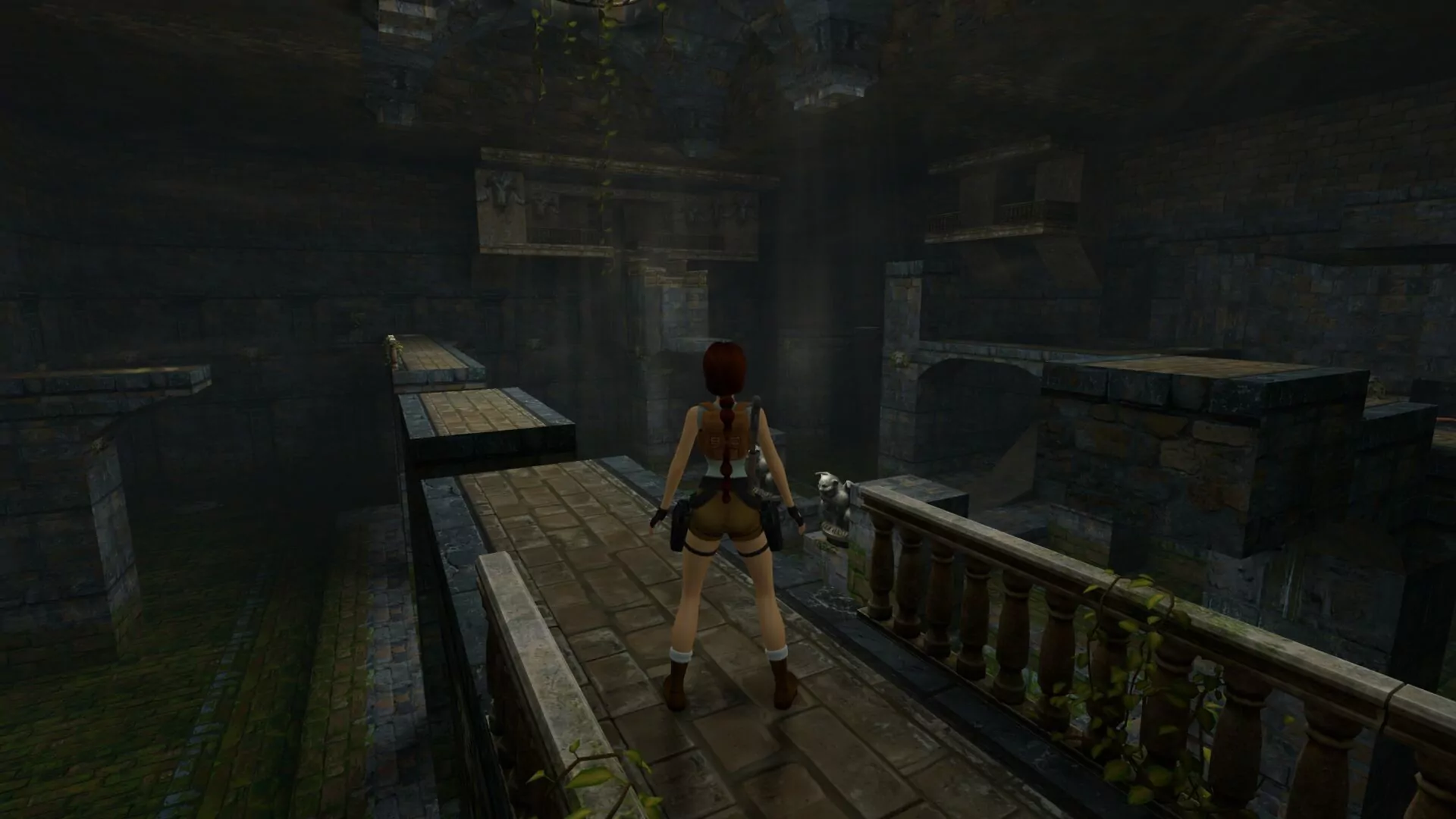This is Lara Croft standing on a platform and looking toward the water level in the main hall of the Tomb Raider I cistern level.